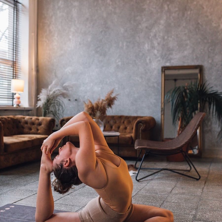Person performing a slow yoga movement in a minimalist room